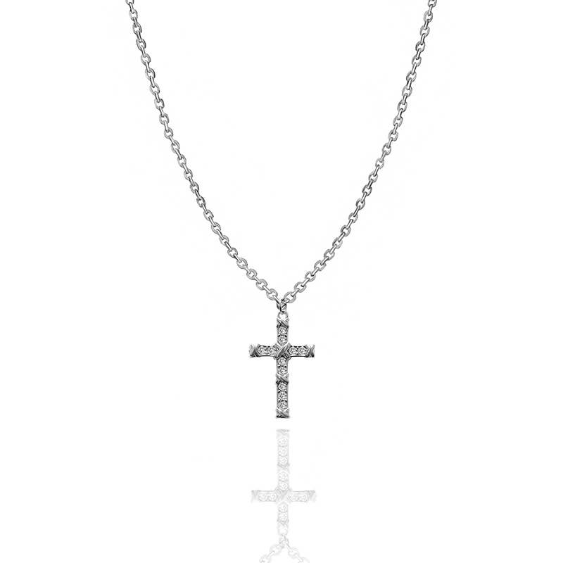 Collier avec chaîne en maille jante argentée et pendentif en forme de croix ouvragée, sertie de cristaux blancs brillants, présenté de face avec son reflet sur fond blanc épuré.