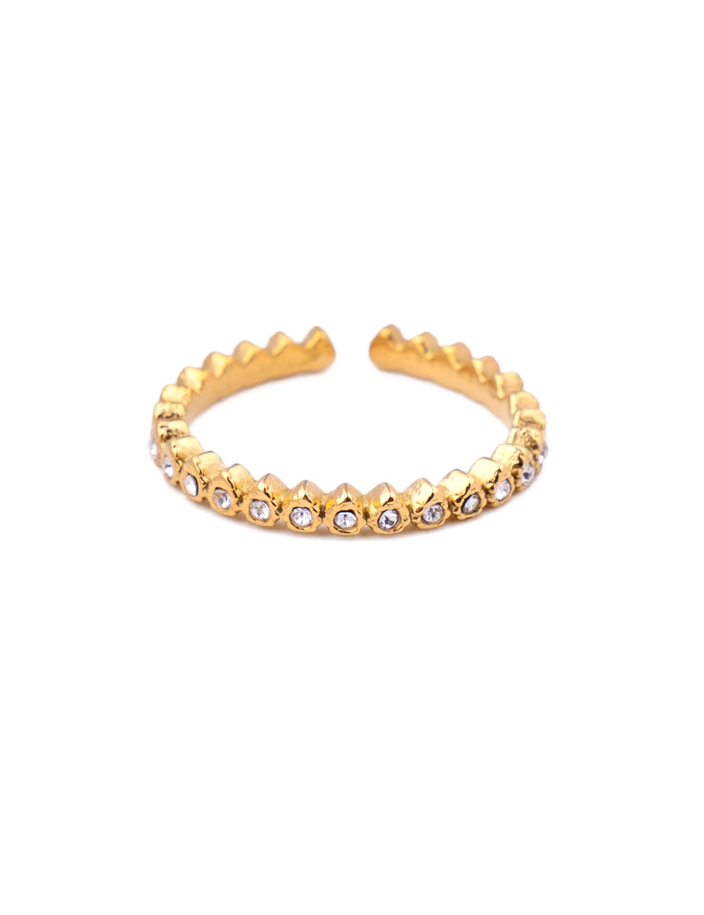 Bague fine ajustable en acier inoxydable doré avec un anneau sculpté en pointes géométriques et pavé sur l'avant d'une rangée de petits oxydes de zirconium ronds blancs, photographiée de face sur fond blanc épuré.