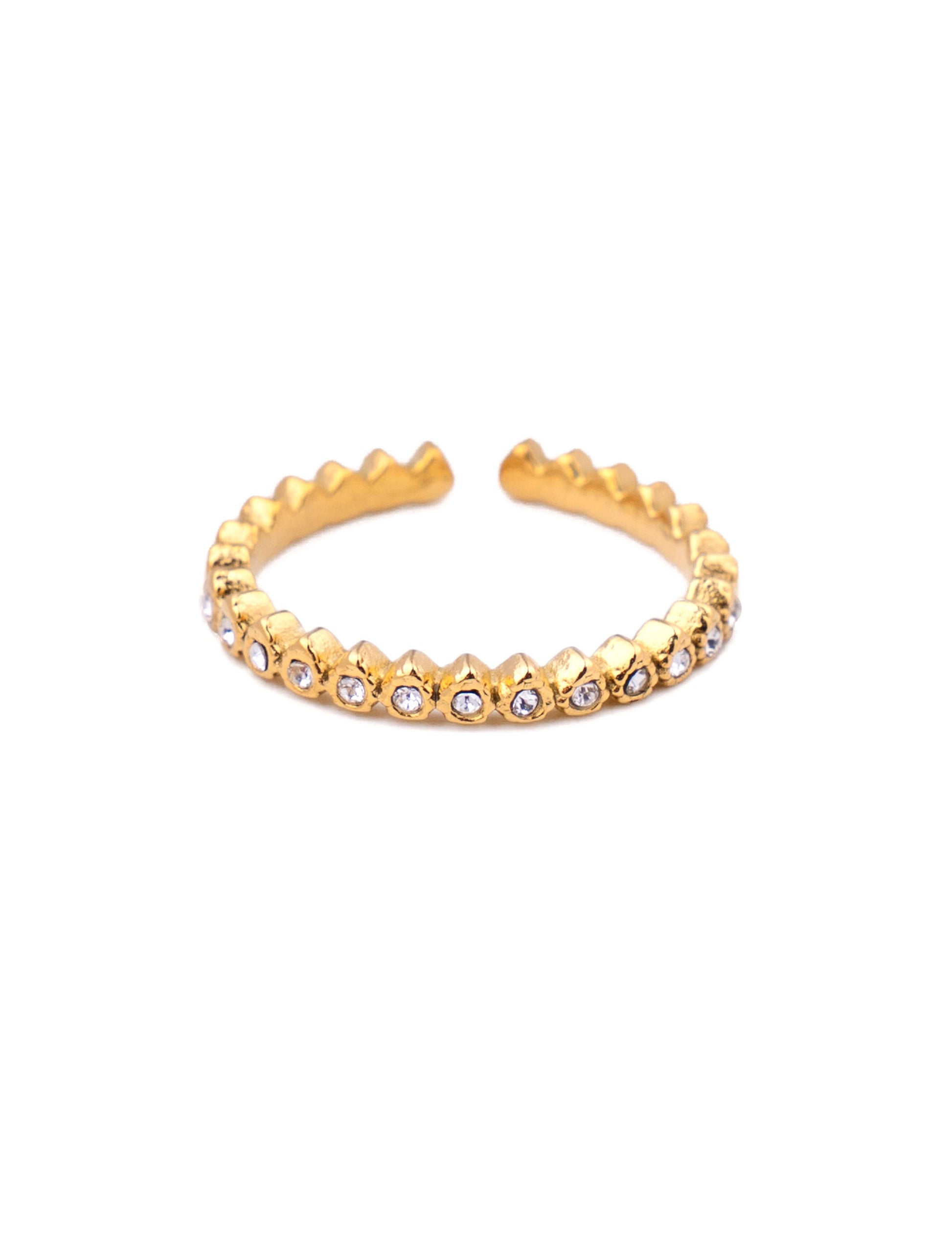 Bague fine ajustable en acier inoxydable doré avec un anneau sculpté en pointes géométriques et pavé sur l'avant d'une rangée de petits oxydes de zirconium ronds blancs, photographiée de face sur fond blanc épuré.