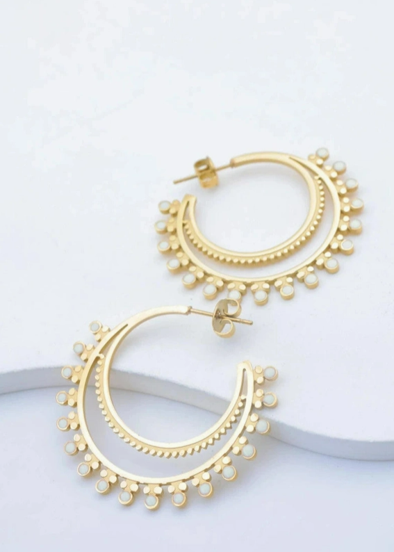 Boucles d'oreilles pendantes demi-lune dorées au design ethnique chic avec petites touches d'émail blanc.