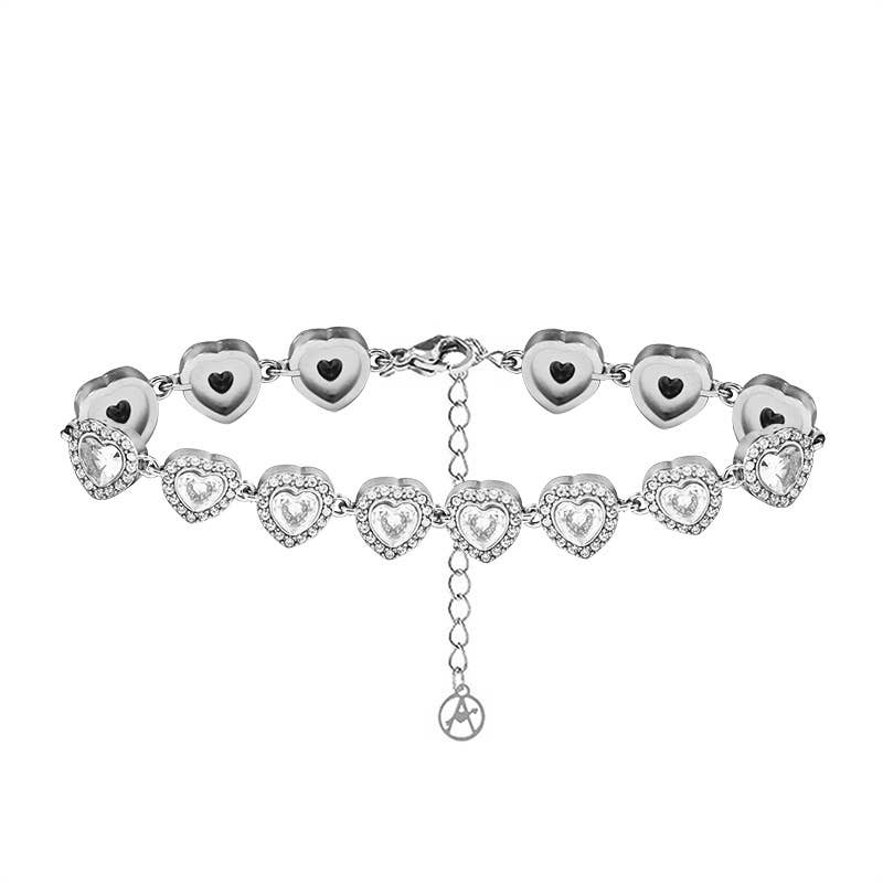 Bracelet argenté articulé composé d'une suite de maillons en forme de cœurs sertis de cristaux blancs transparents et entourés de strass brillants, présenté de face sur fond blanc.