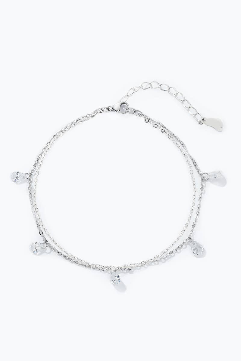 Bracelet de Cheville Double Rang et Gouttes Étincelantes REF 165 - Chaîne de cheville double rang argentée en acier inoxydable pour femme avec 5 cristaux clairs en forme de gouttes suspendues.