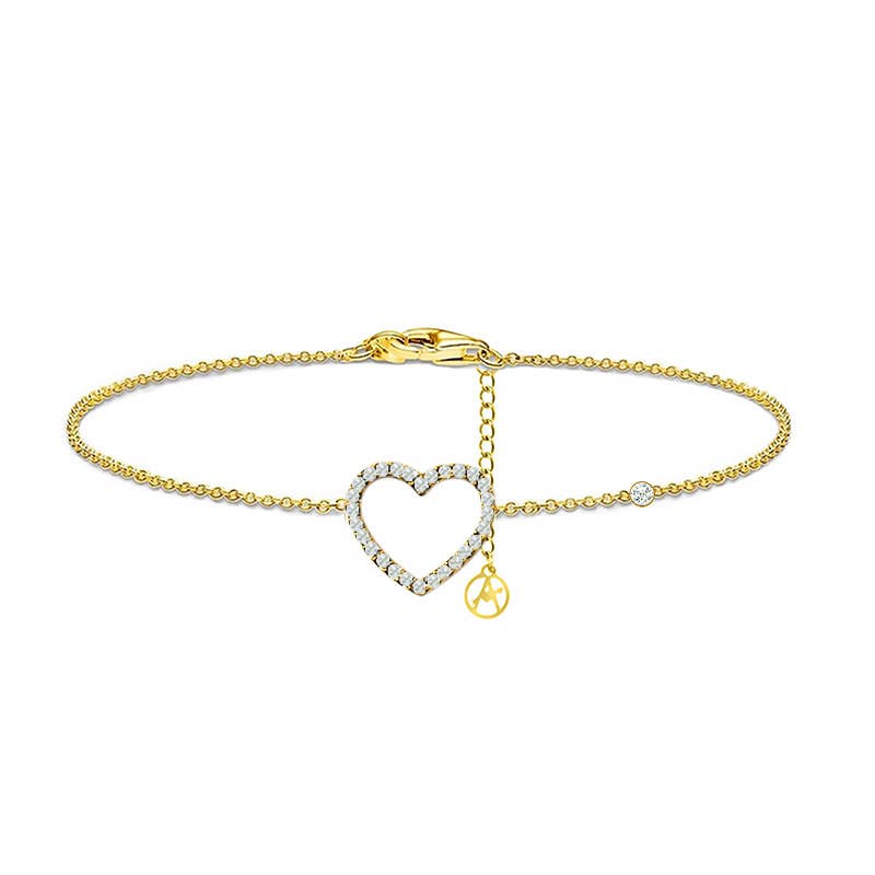 Bracelet chaîne fin doré avec un pendentif central en forme de cœur évidé pavé de petits cristaux blancs, un petit strass solitaire excentré et un fermoir mousqueton avec chaînette de réglage