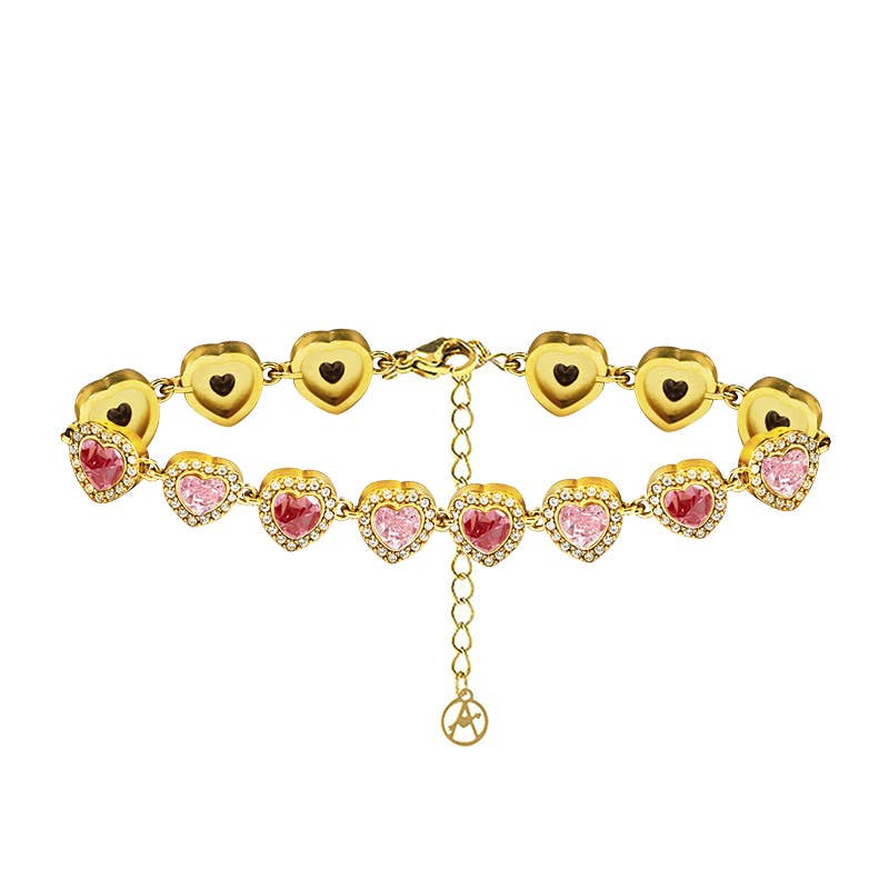 Bracelet doré articulé composé d'une suite de maillons en forme de cœurs sertis de cristaux roses et entourés de petits strass blancs, présenté de face sur fond blanc.