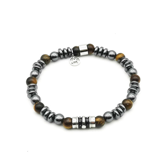 Bracelet élastique pour homme composé de perles rondes en œil de tigre marron, de billes et disques en hématite gris foncé métallisé, agrémenté d'un cylindre central en acier gravé et d'une breloque logo.