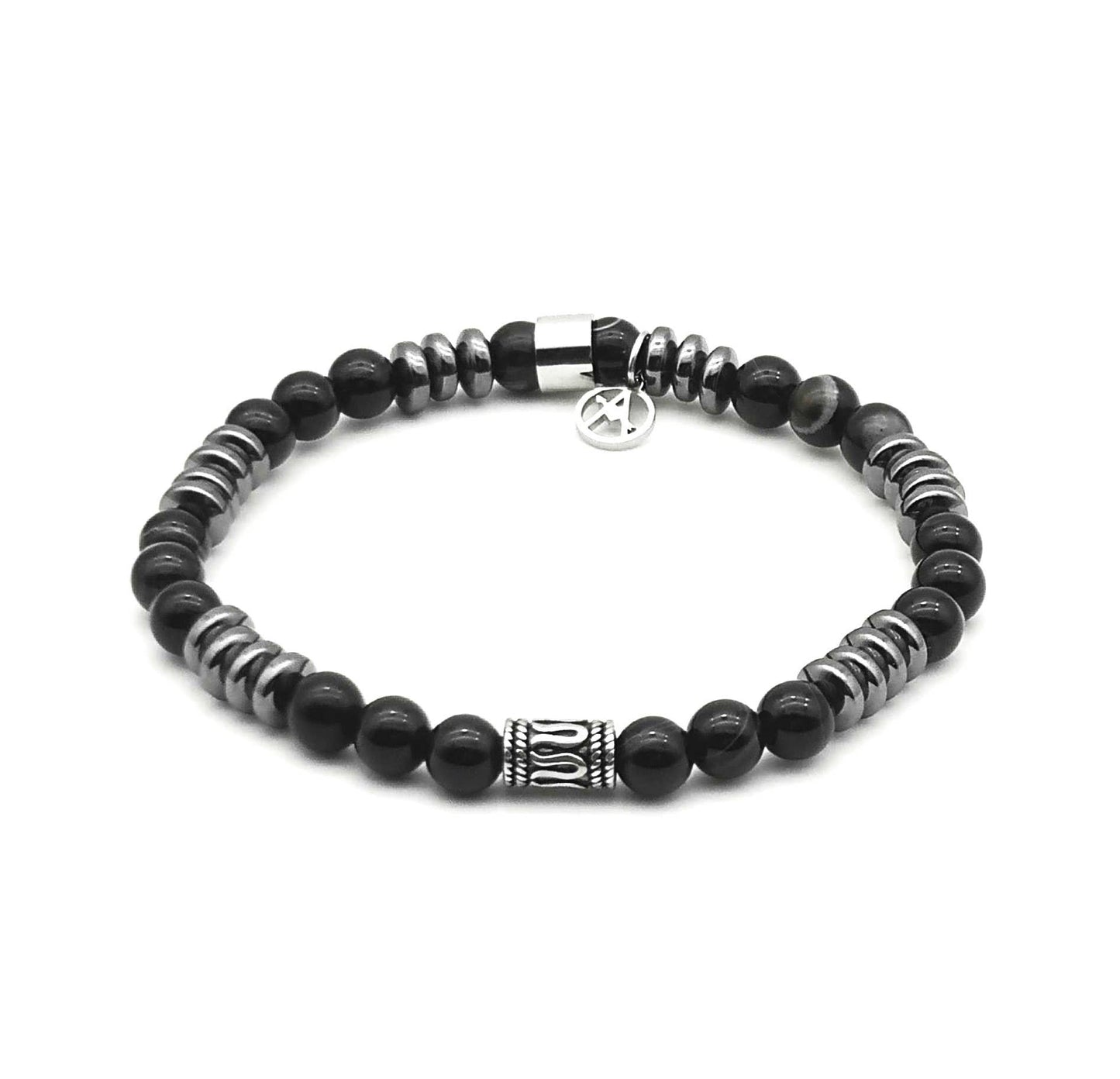 Bracelet élastique pour homme composé de perles rondes en agate noire onyx brillante, espacées par des disques en hématite métallique gris foncé, avec un intercalaire central cylindrique en acier sculpté et une breloque logo de la marque.