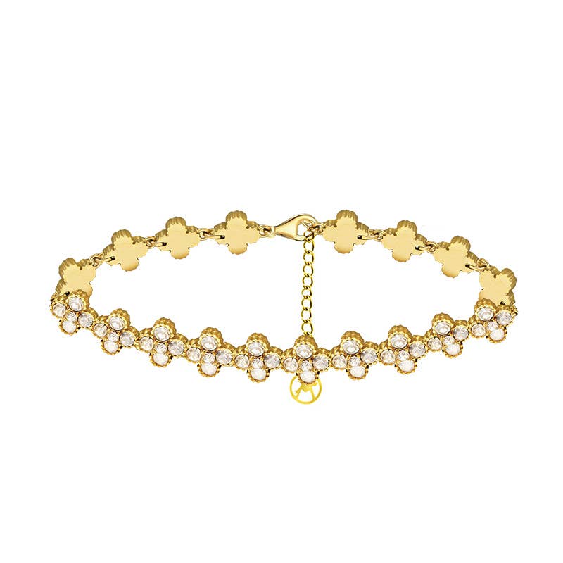 Bracelet chaîne doré pour femme composé de trèfles à quatre feuilles pavés de cristaux blancs étincelants.