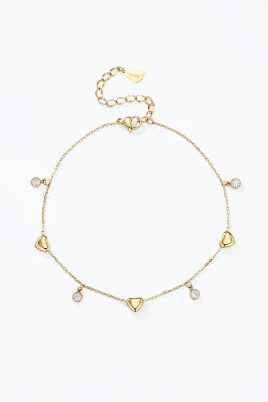 Chaîne de cheville dorée pour femme en acier inoxydable avec breloques cœurs bombés et cristaux blancs suspendus.