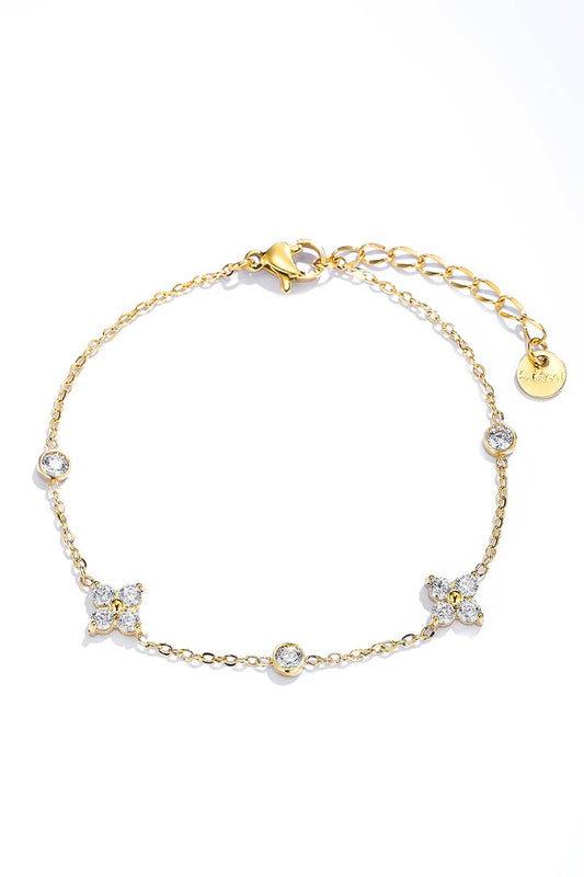 Chaîne de cheville dorée pour femme en acier inoxydable avec motifs fleurs en strass et pampilles de cristaux ronds sertis clos.