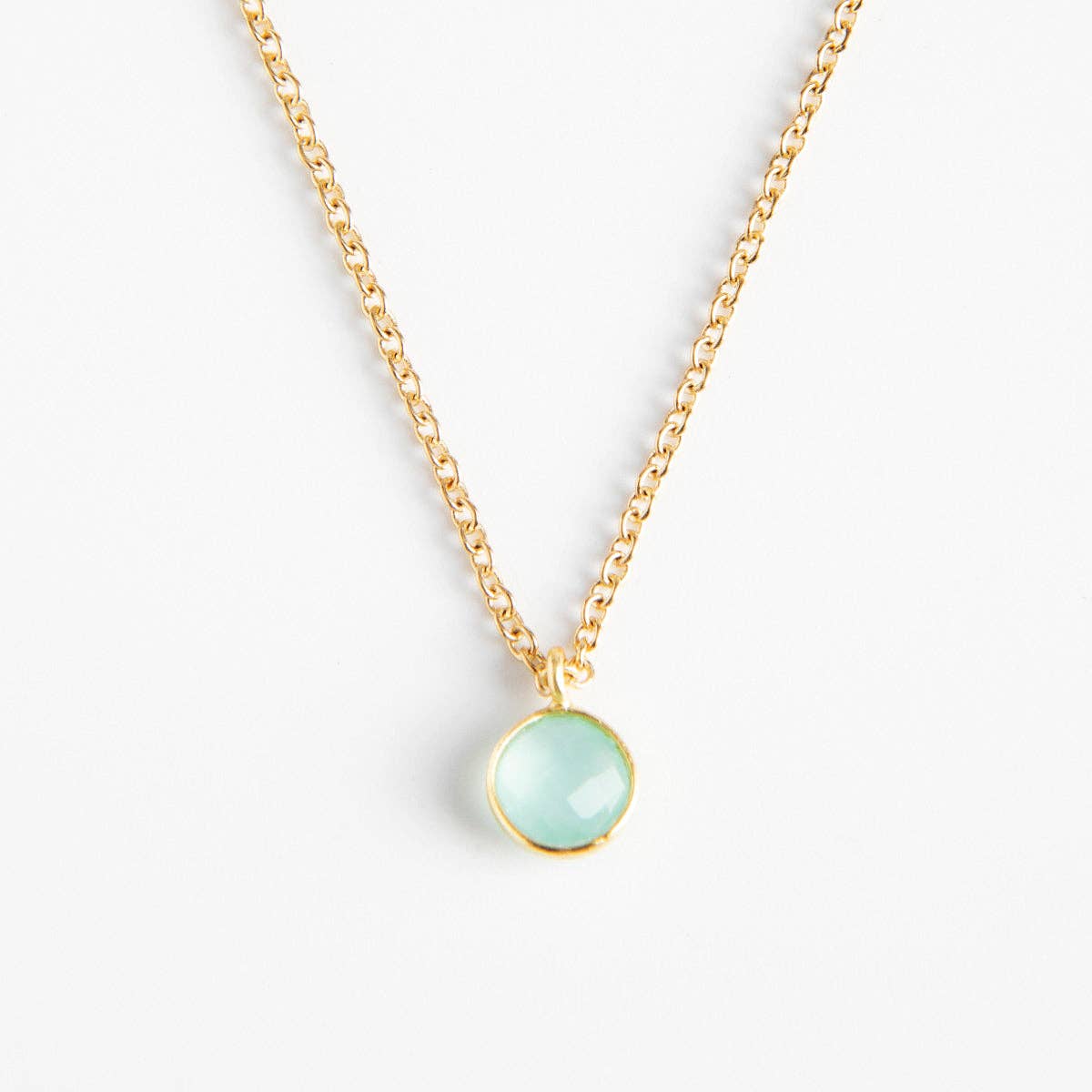 Collier doré Céleste REF 148 pour femme avec chaîne fine en maille forçat et pendentif rond serti clos couleur bleu aigue-marine pastel facettée.