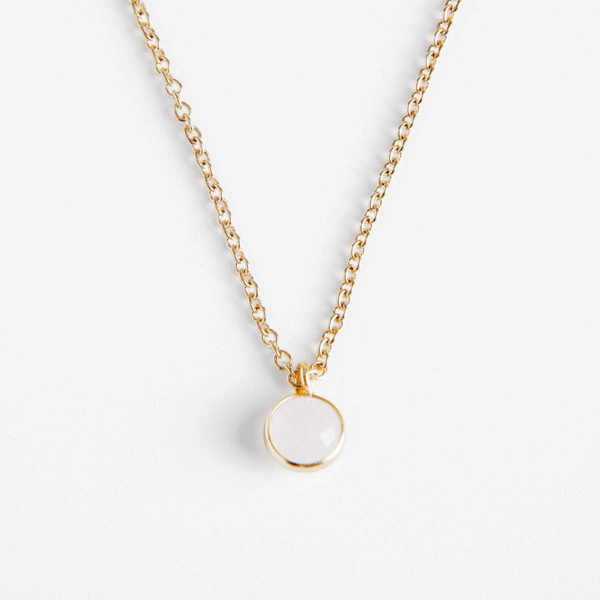 Collier doré Céleste REF 145 pour femme avec chaîne fine en maille forçat et pendentif rond serti clos couleur blanc laiteux opalin facettée.