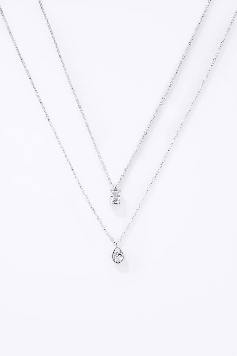 Collier deux rangs argenté orné d’un oxyde de zirconium de forme émeraude et d’un cristal poire scintillant.
