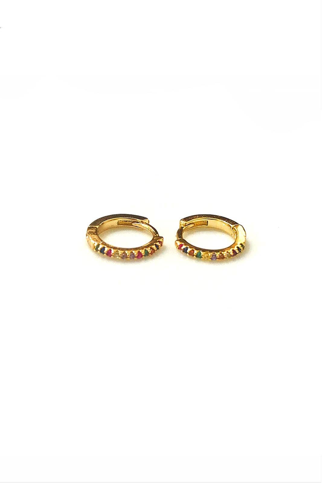 Paire de petites boucles d'oreilles créoles huggies en acier inoxydable doré, ornées sur la face avant d'une rangée de petits cristaux multicolores scintillants, posées sur un fond blanc épuré.