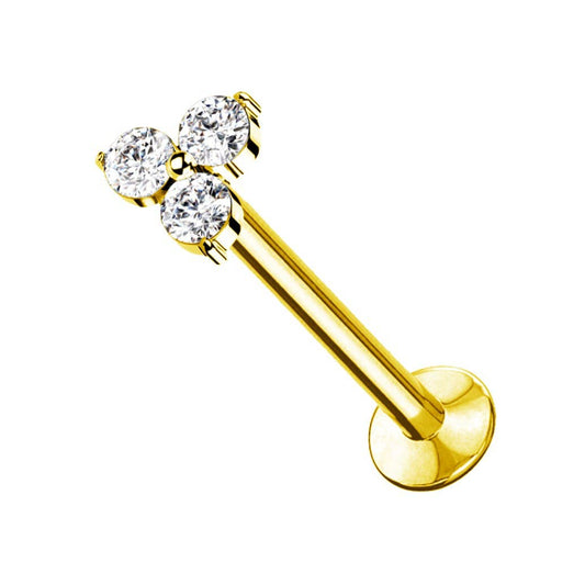 Piercing de type labret doré à fond plat orné d'un motif trinité composé de trois cristaux blancs ronds et étincelants, présenté de trois-quarts sur fond blanc.
