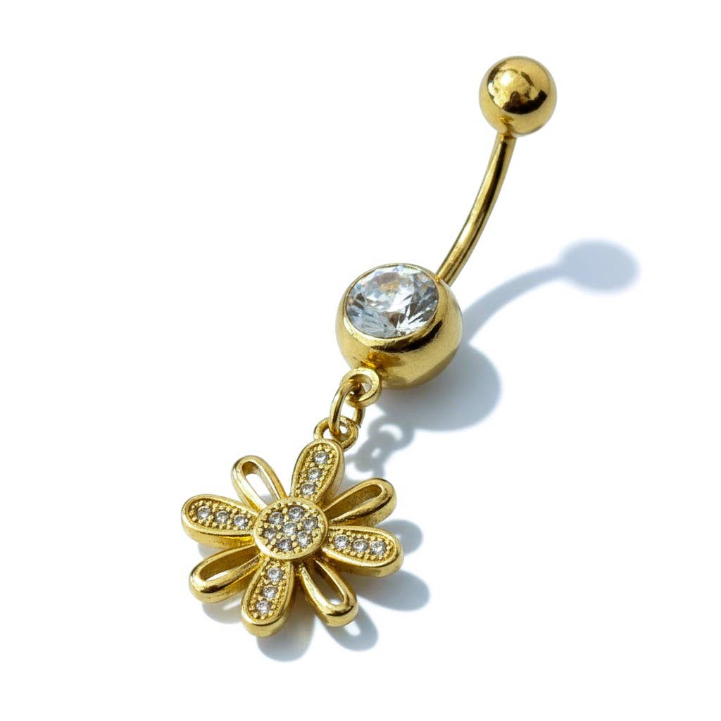 Piercing de nombril pendant en acier inoxydable doré, doté d'une tige courbée à bille, d'un gros cristal rond blanc et d'un pendentif en forme de fleur aux pétales alternés lisses et pavés de strass, sur fond blanc avec ombre portée.