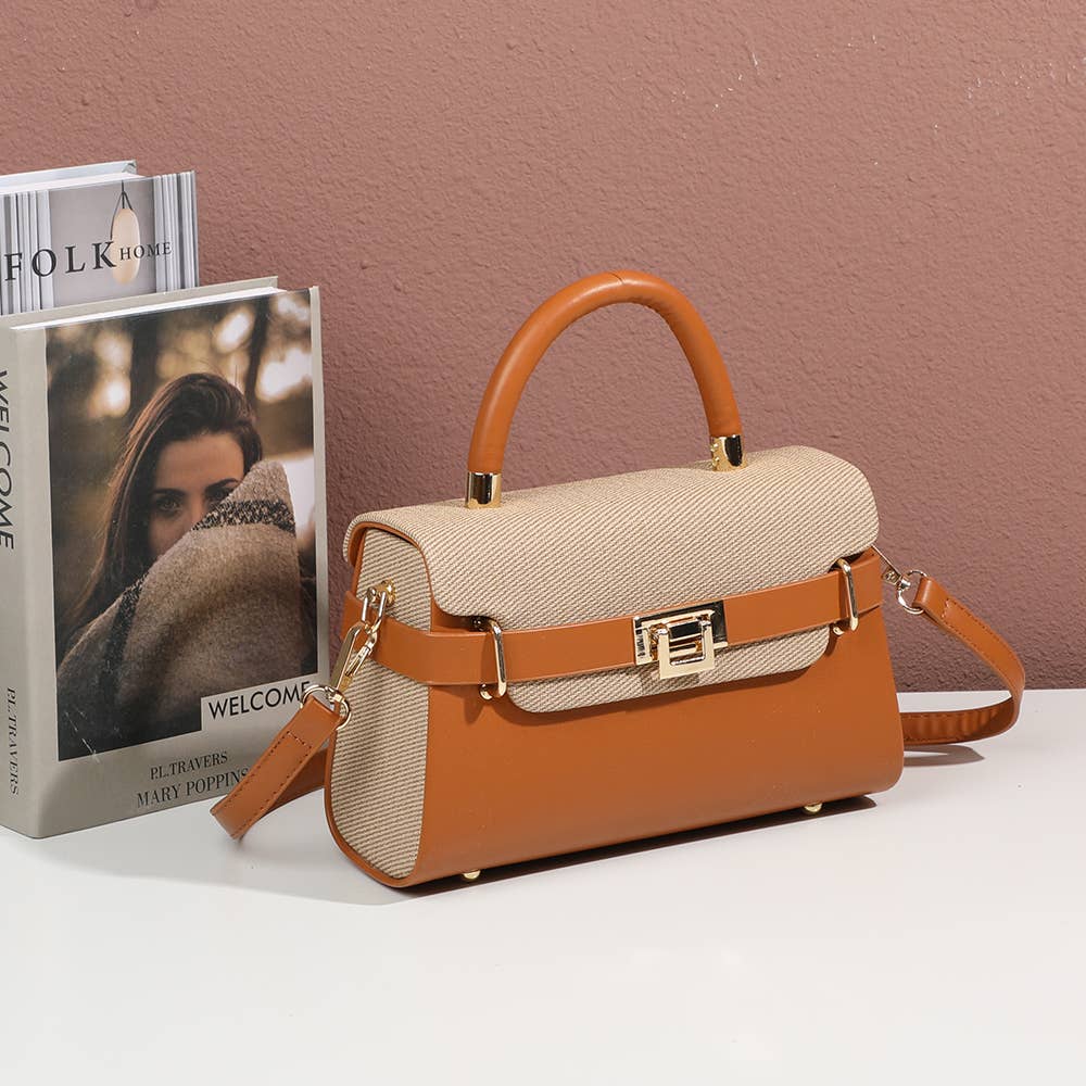 Sac à main trapèze Lysia marron (REF 45) avec rabat en toile tressée beige naturel, sangle ceinturée à fermoir doré et bandoulière en cuir synthétique, photographié de trois-quarts à côté de livres de décoration sur une table blanche.